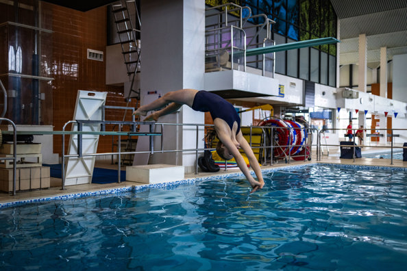 Swimmer diving into indoor swimming pool