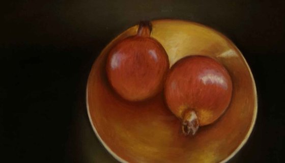 2 Pomegranates sitting in a bowl